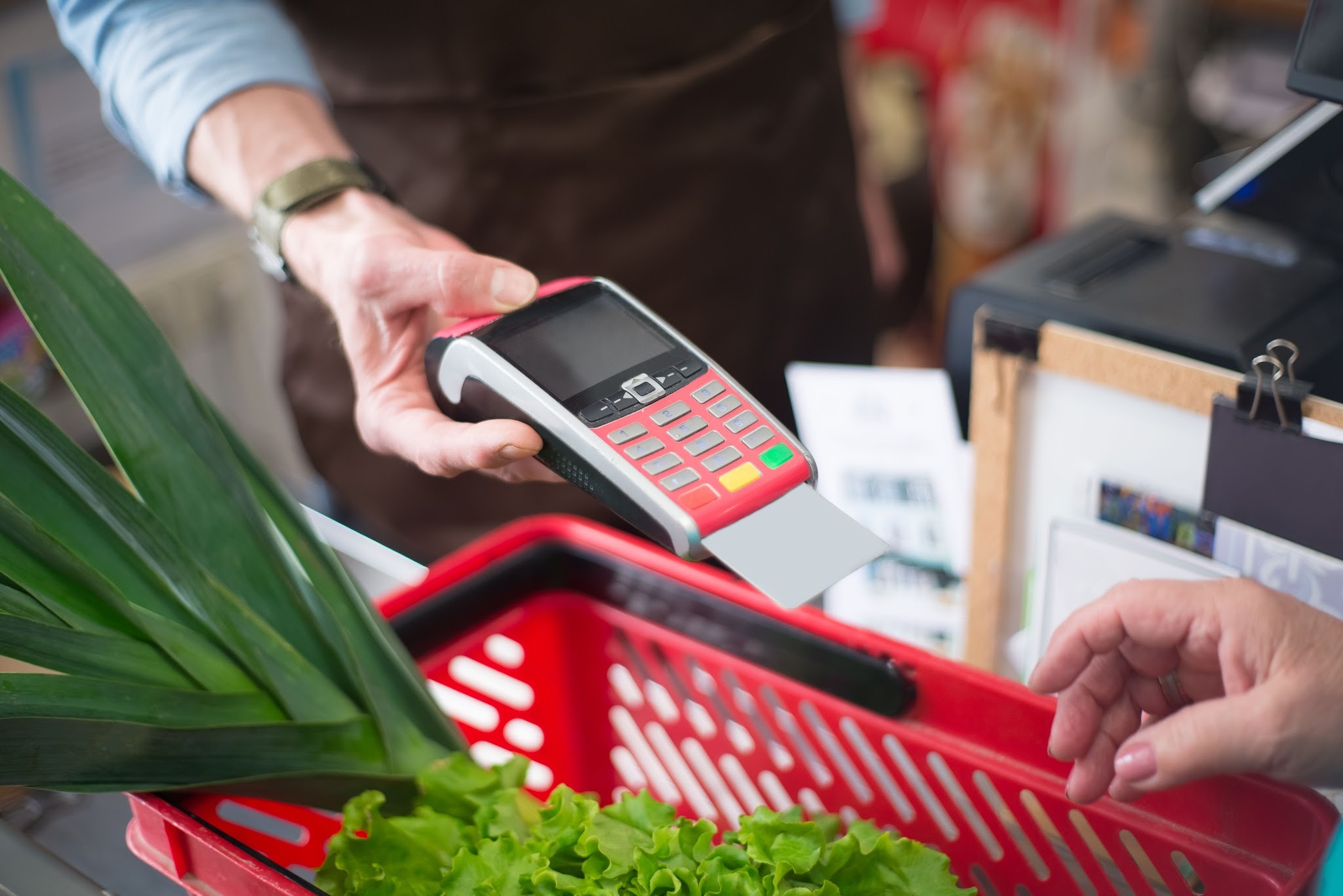 Someone paying for groceries with a card reader at the store